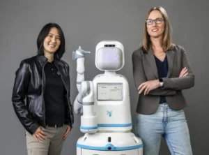 Co-founders of Diligent Robotics, Dr. Vivian Chu (Left), and Dr. Andrea Thomaz (Right), with their robot Moxi at the center.Diligent Robotics